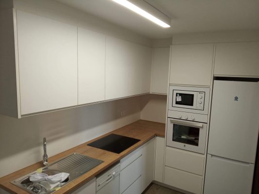 Muebles de cocina con una configuración en L realizada en material laminado.